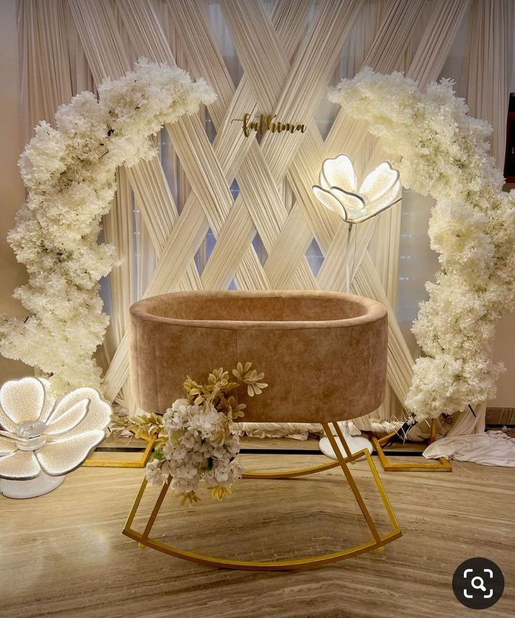 Beautifully decorated banquet hall set up for a name ceremony, featuring floral arrangements and elegant seating.