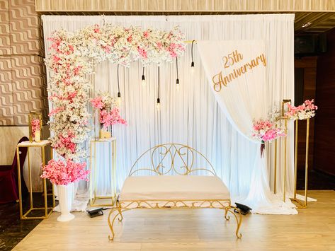 Elegant anniversary celebration setup in a beautifully decorated banquet hall with floral arrangements.